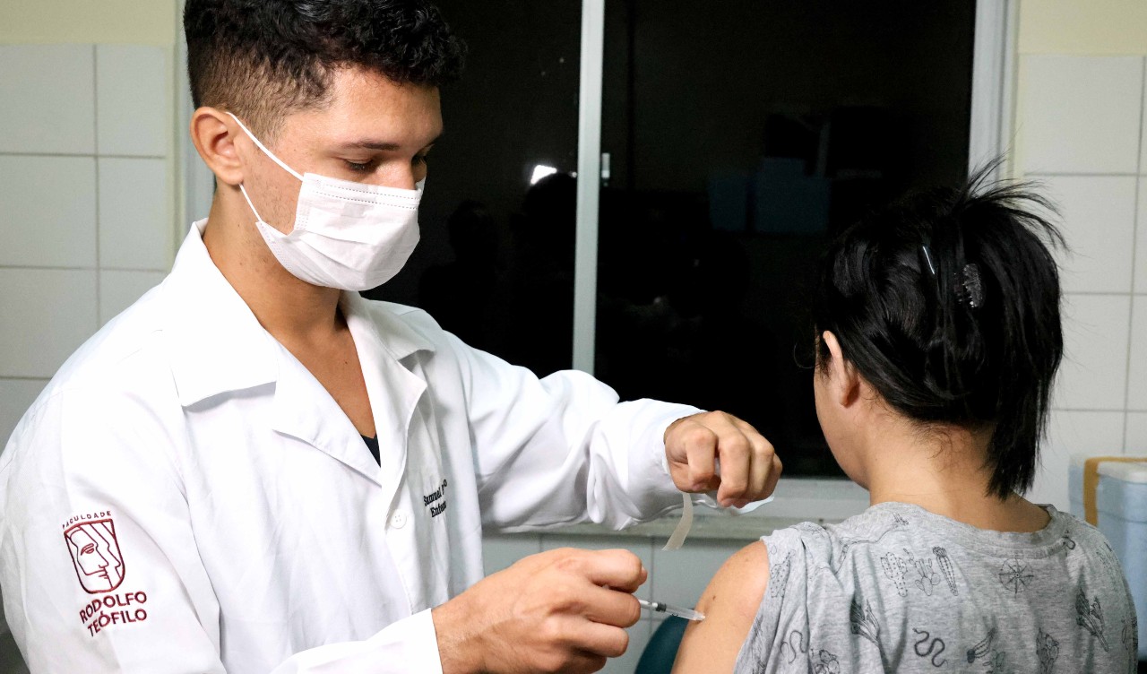 enfermeiro vacina uma mulher que está de costas